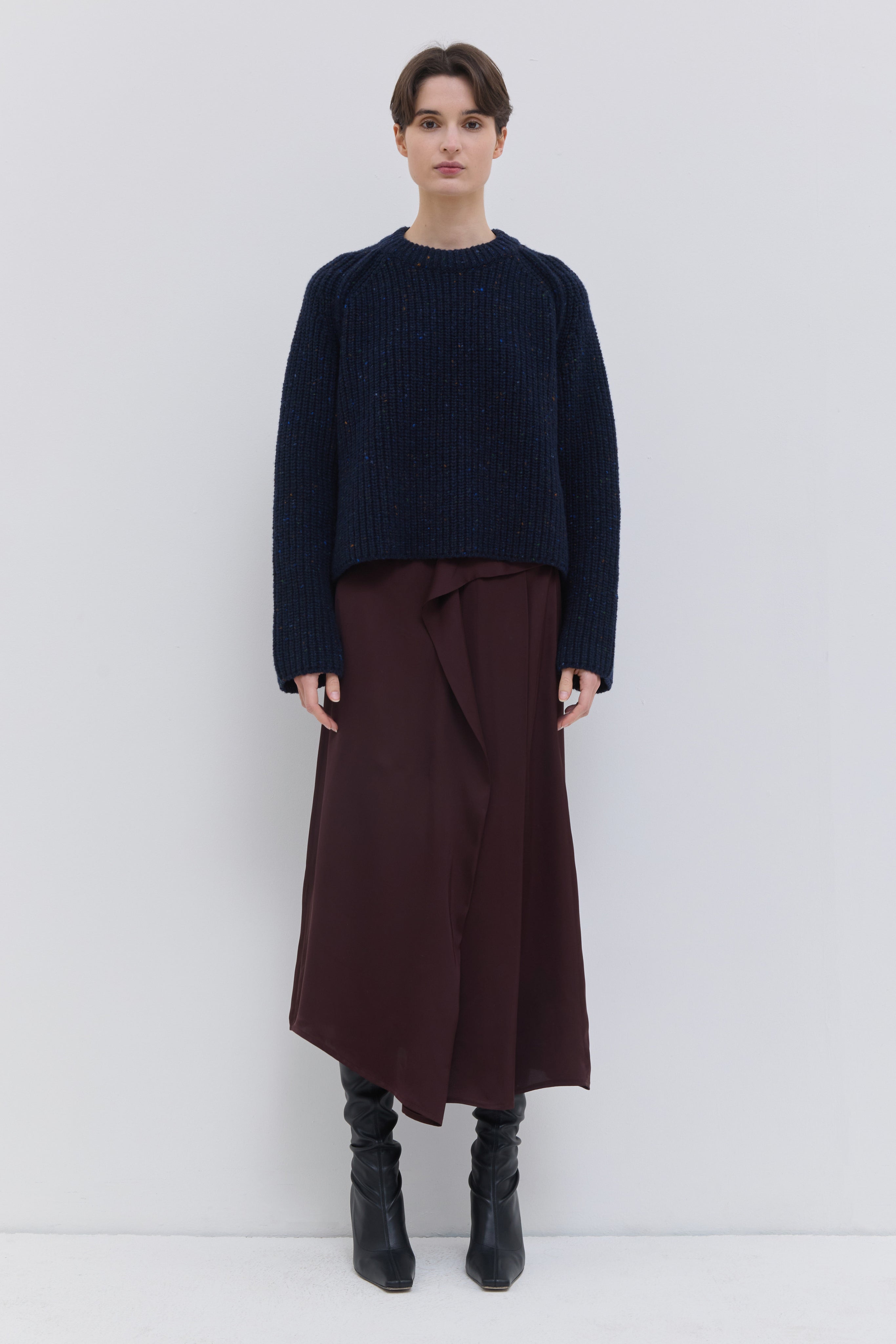 Sedona draped skirt in plum with an asymmetric layered front and fluid silhouette.
