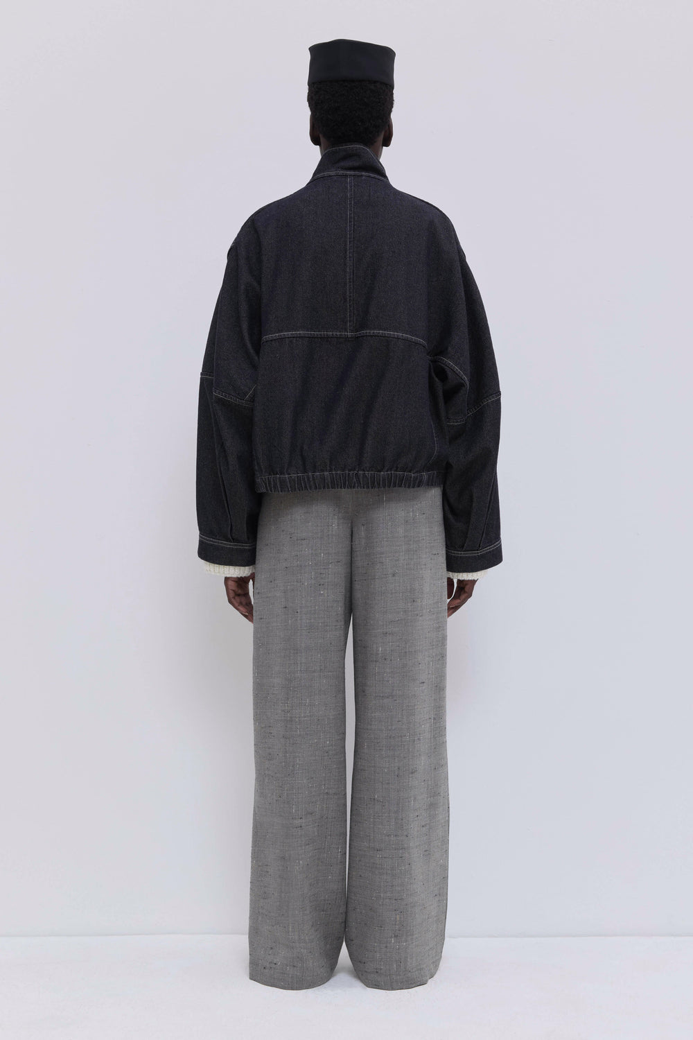 Front view of a cropped denim jacket in raw dark denim with oversized fit.