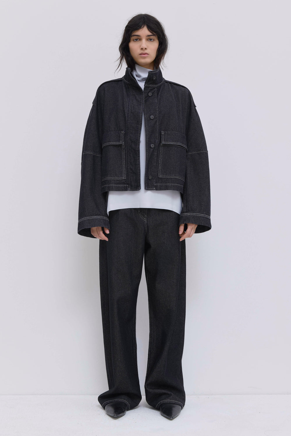 Side view of a raw denim cropped jacket with statement sleeves.
