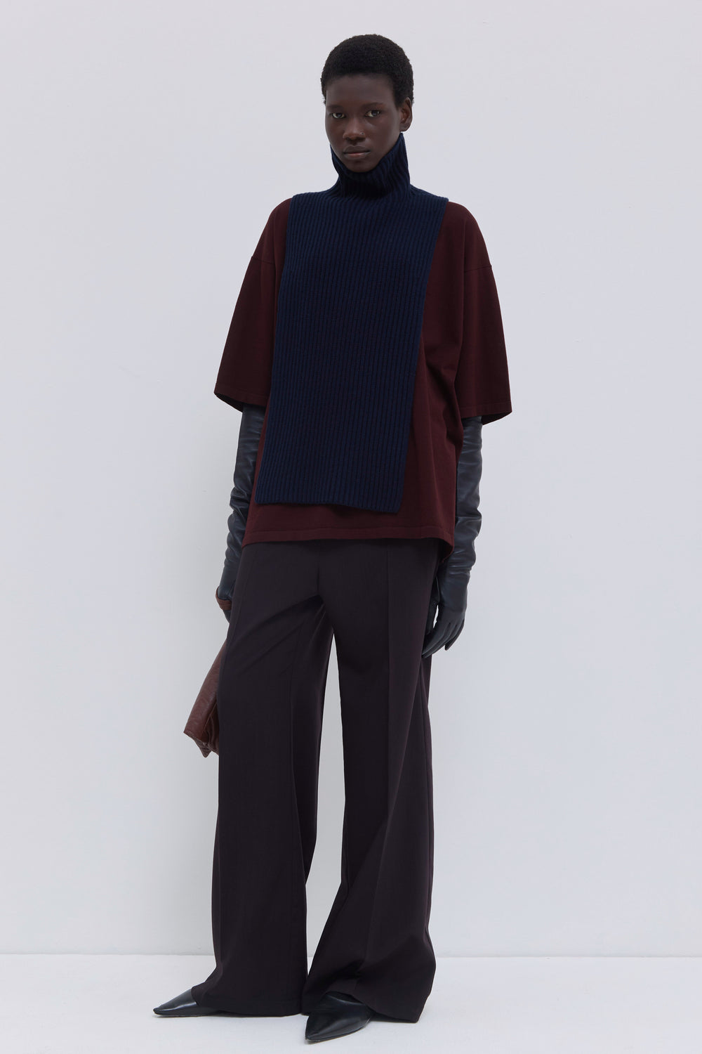 Dark marine ribbed merino wool and cashmere knit bib with high ribbed turtleneck styled over a burgundy cotton T-shirt.