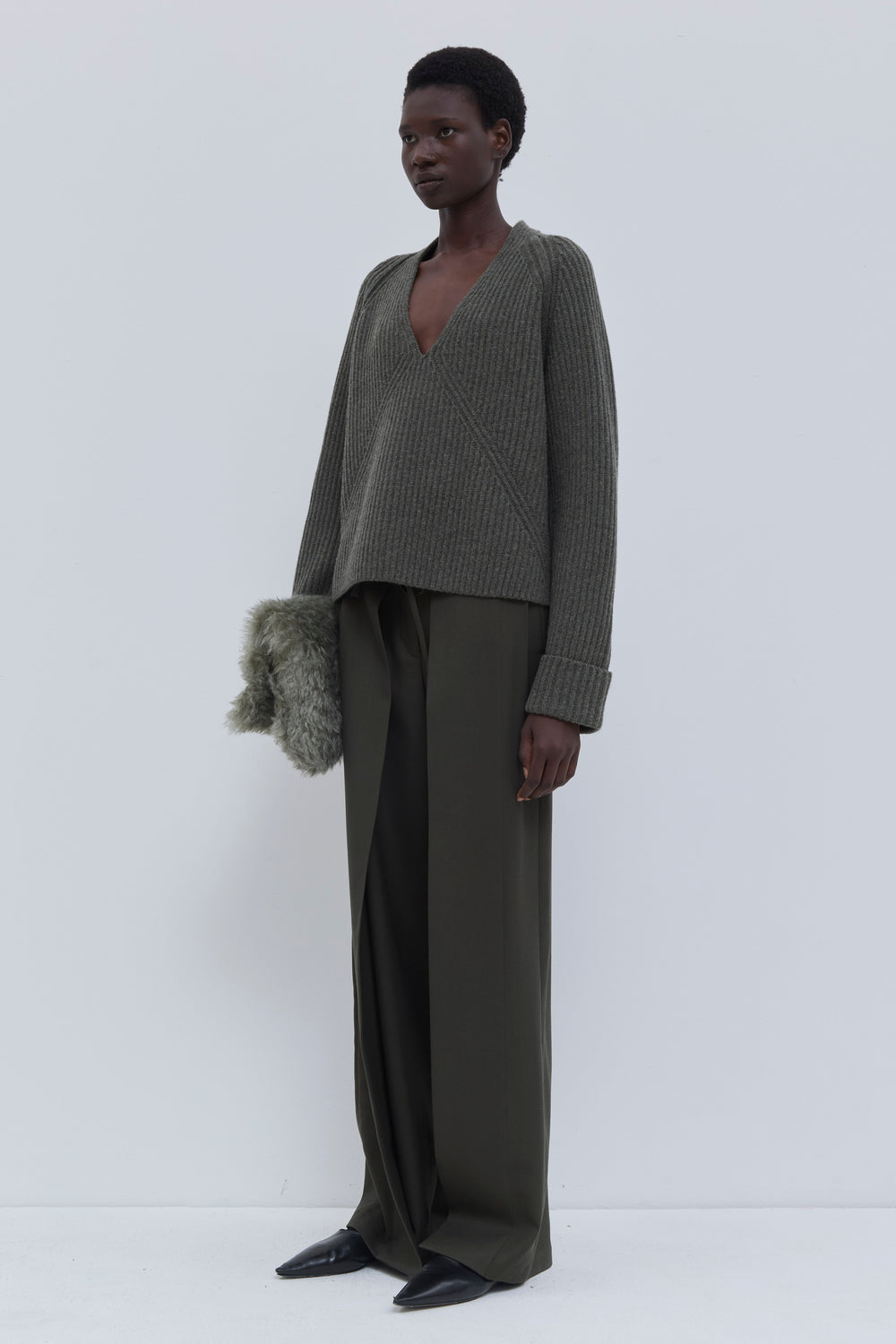 Side view of the forest melange ribbed merino wool and cashmere V-neck sweater.
