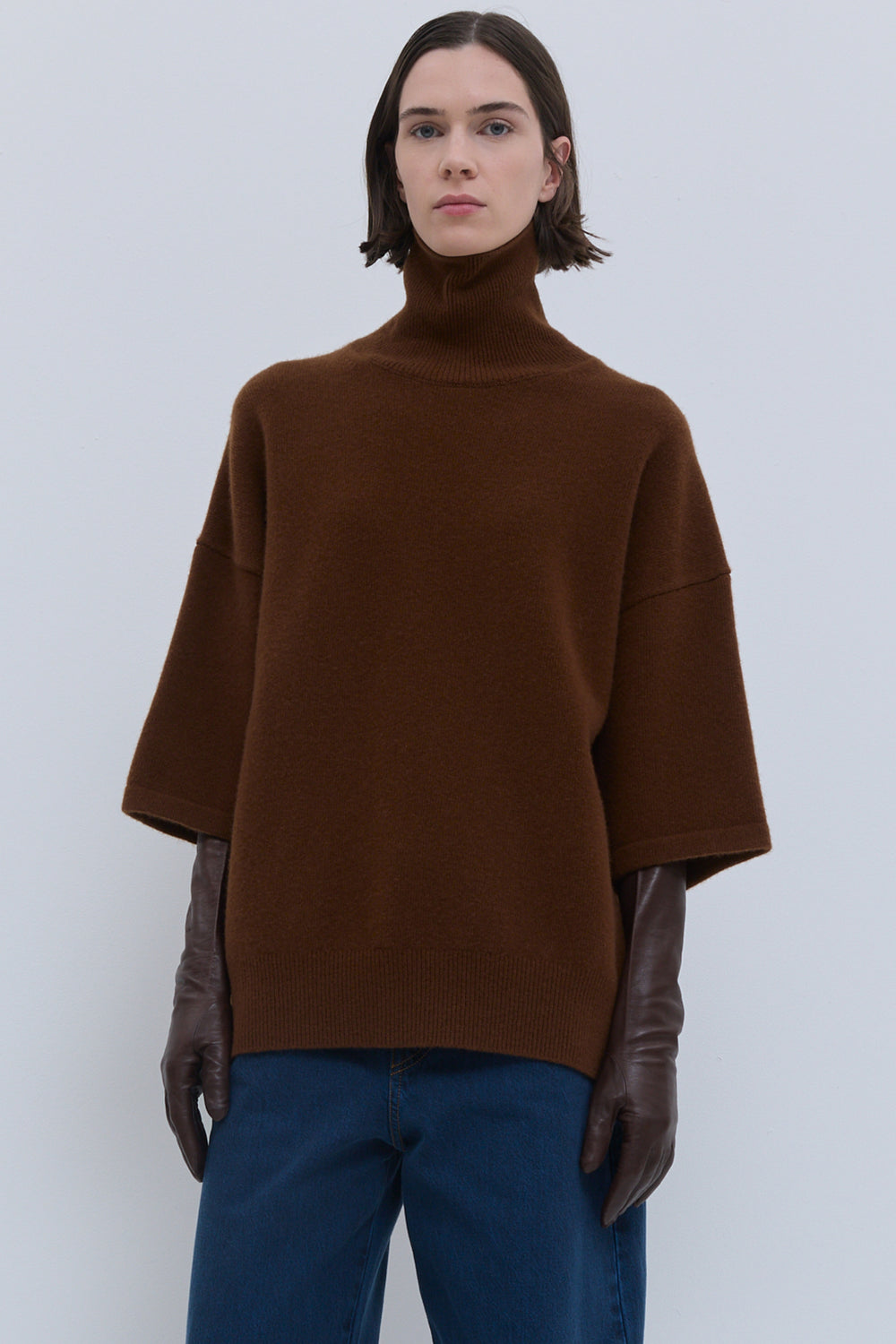 Oversized rust turtleneck sweater styled with wide-leg trousers