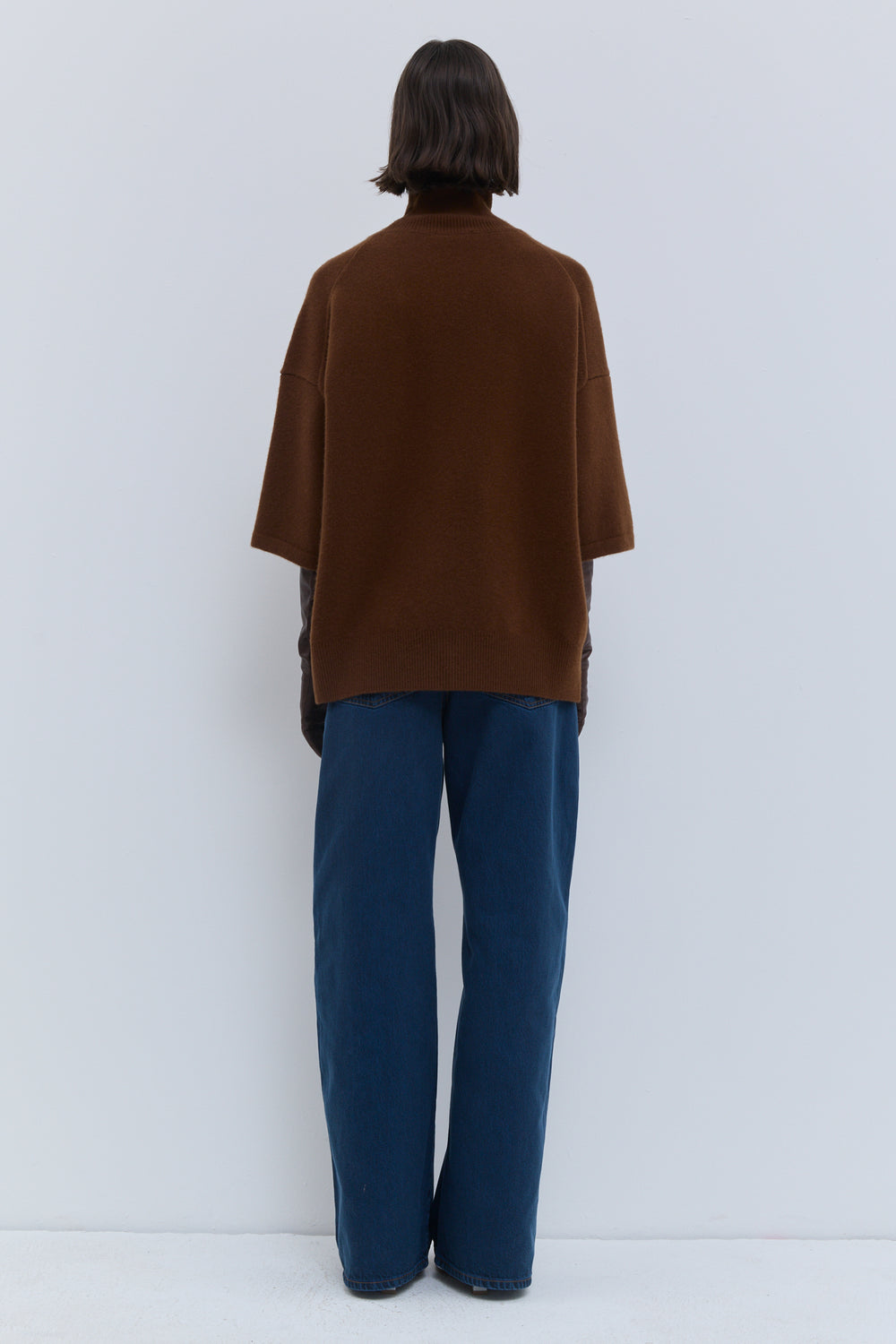 Back view of rust oversized turtleneck knit with wide three-quarter sleeves Christian Wijnants
