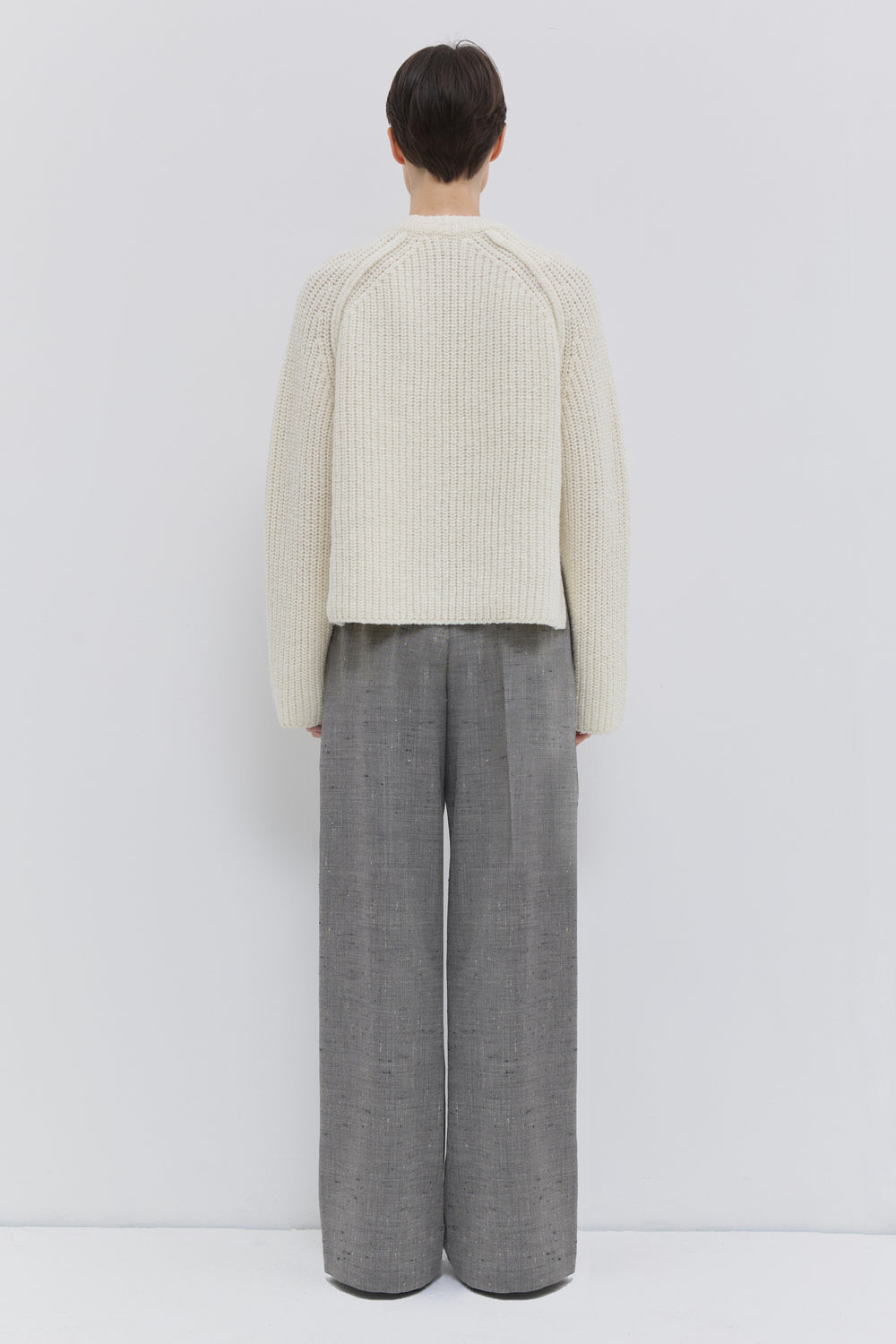 Back view of the Pama classic wide-leg trousers in oat chartreux virgin wool with front crease.