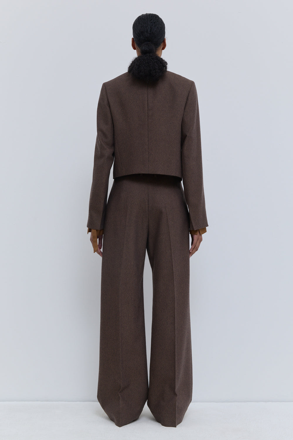 Full-length back view of Christian Wijnants Pamira rust tweed wide-leg trousers in luxurious virgin wool.