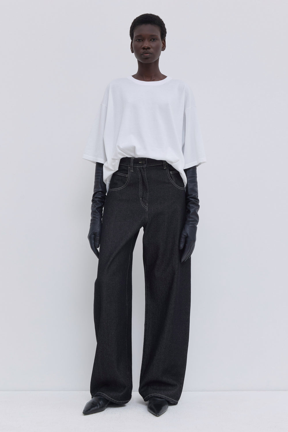 Wide-leg raw denim jeans styled with a white cotton blouse.