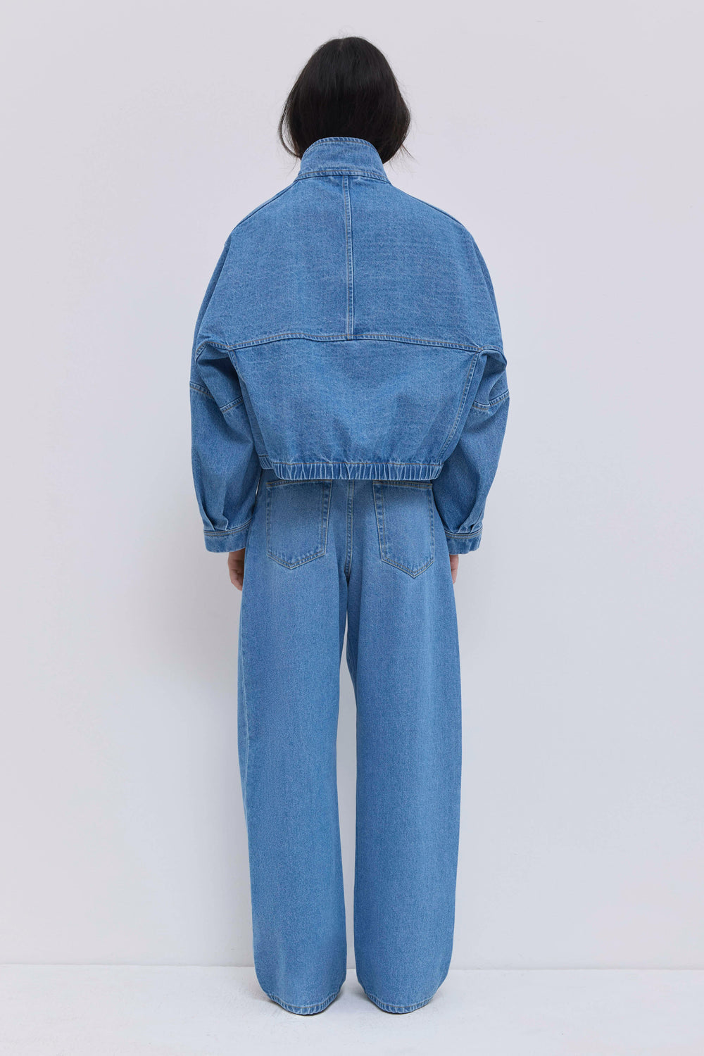 Back view of light blue washed denim jeans with a relaxed wide-leg silhouette.