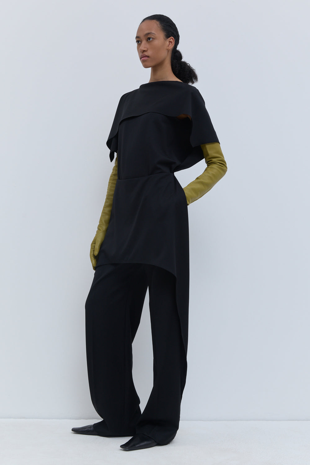 Side view of Christian Wijnants black virgin wool trousers with conceptual layered skirt detail