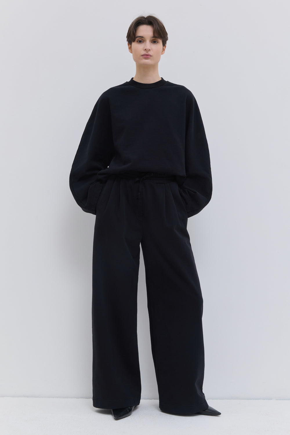 Pishas black garment-dyed jersey sweatpants with wide-leg fit.