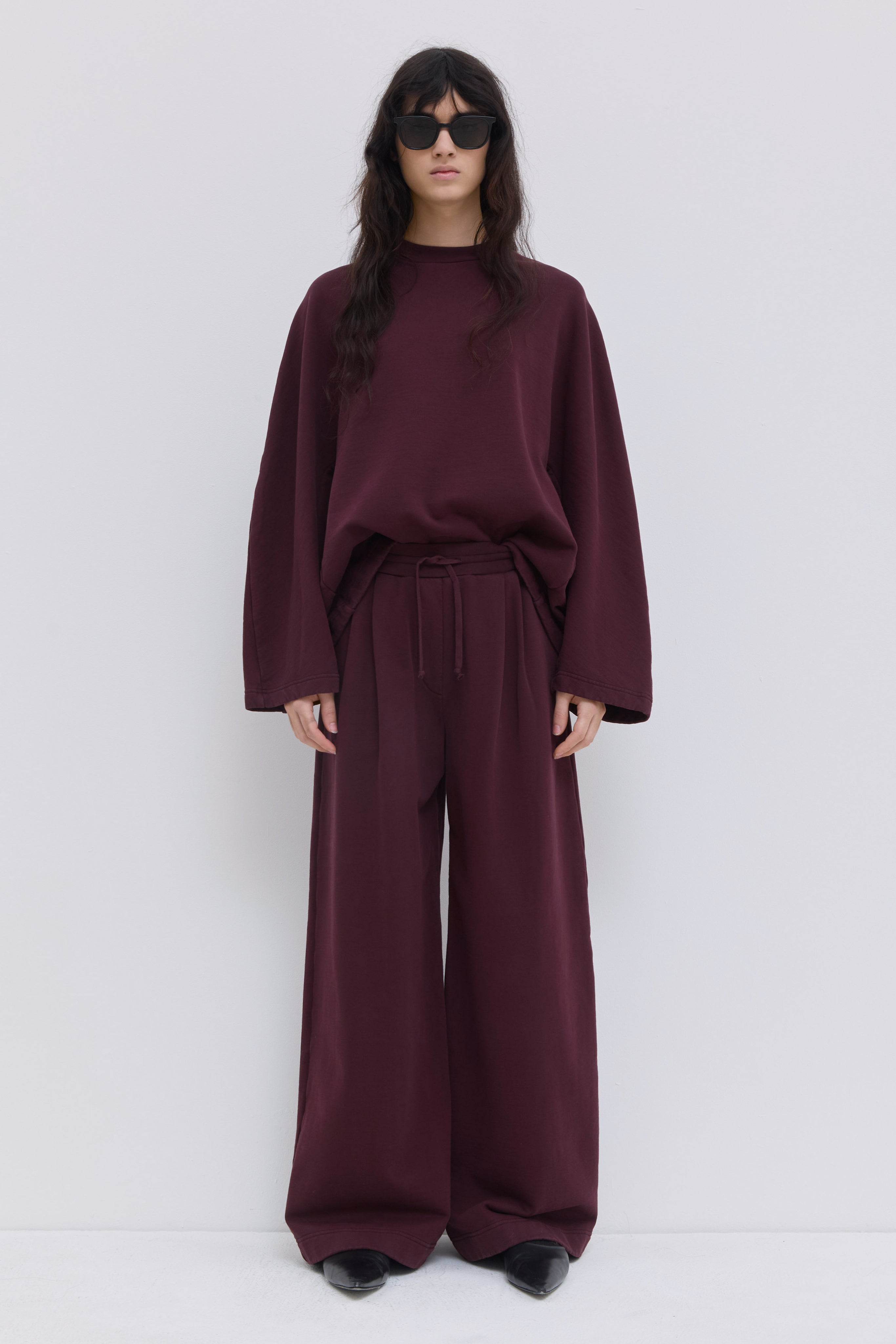 Pishas burgundy garment-dyed jersey sweatpants with wide-leg fit.