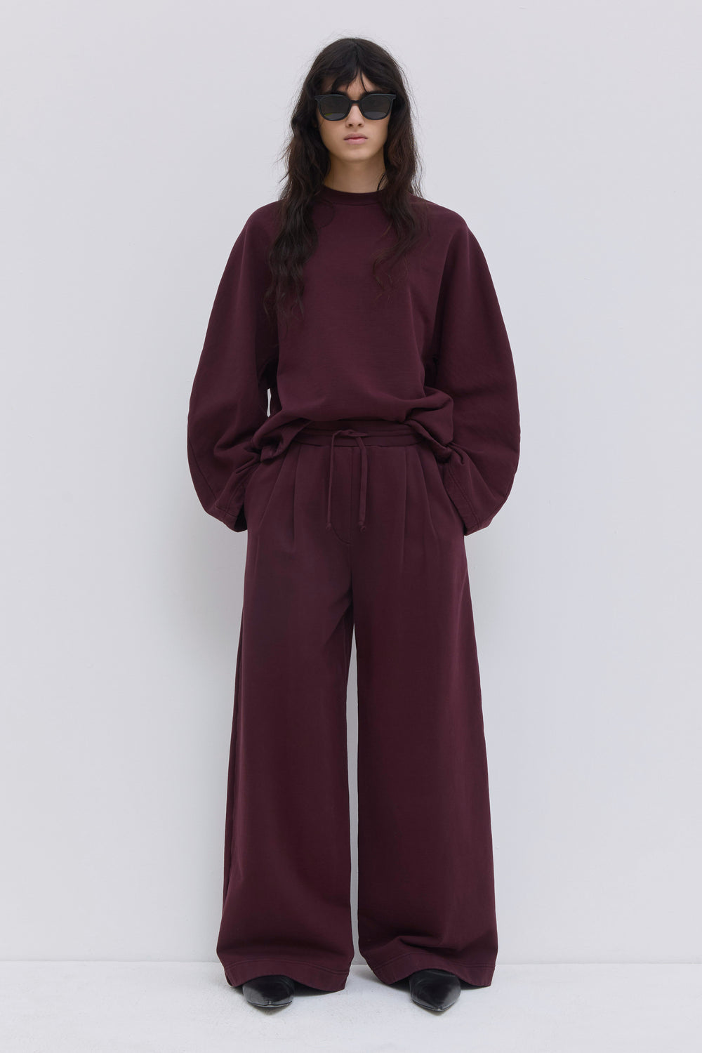 Front view of burgundy wide-leg jersey sweatpants with drawstring waist.