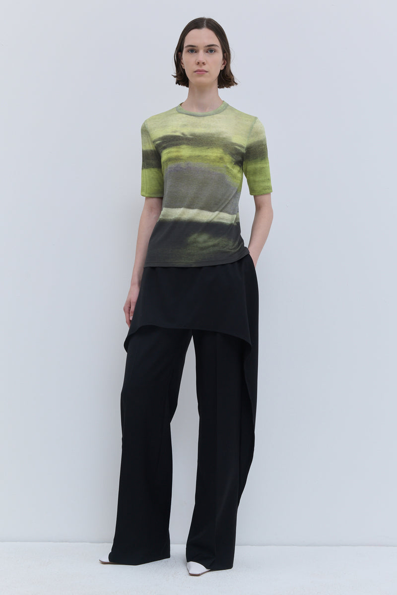 Model wearing the Tampi short-sleeve wool jersey top in Day Break print, featuring a close-fitting silhouette and abstract green landscape-inspired print.