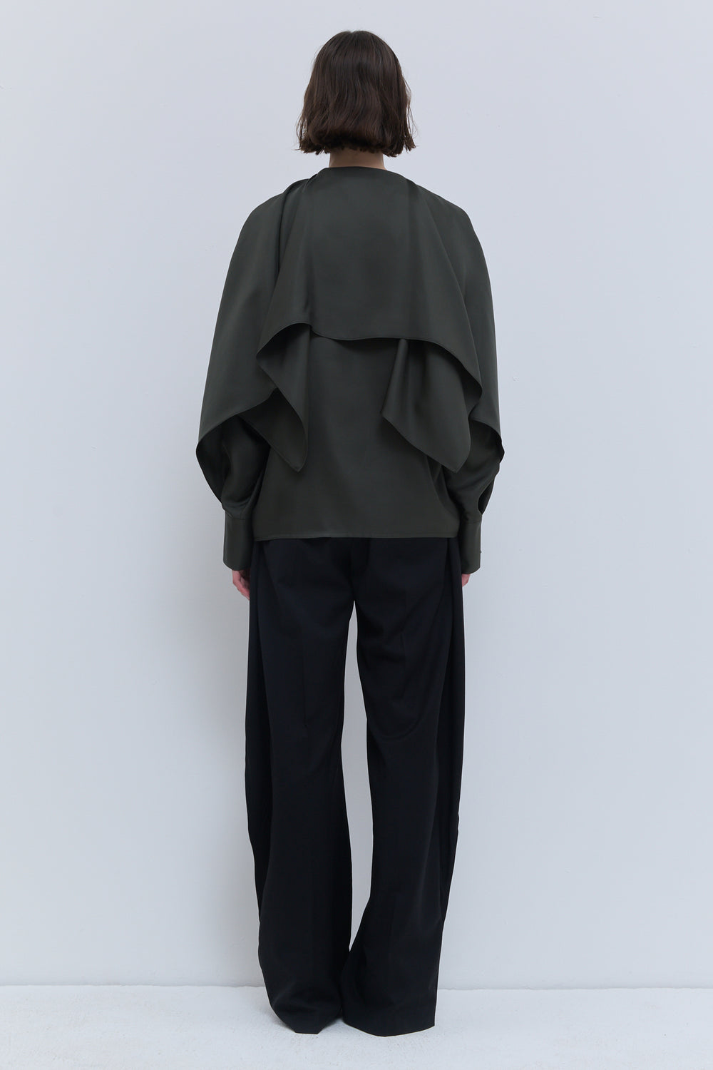 Luxury thyme green silk top with fluid batwing sleeves and integrated scarf detail knotted at the front